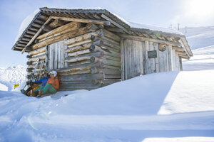 Skifahrer vor einer urigen Almhütte